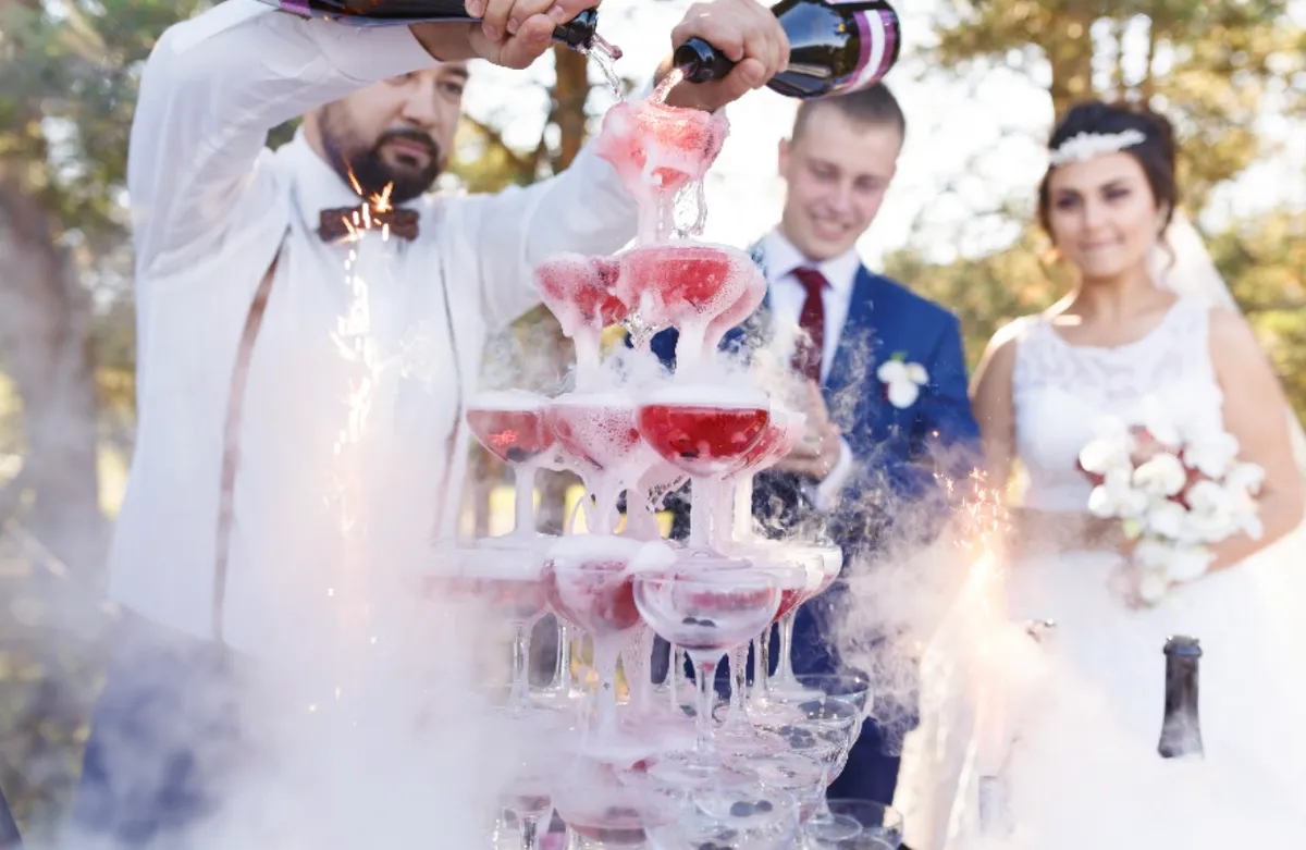 person in red sweater holding babys hand